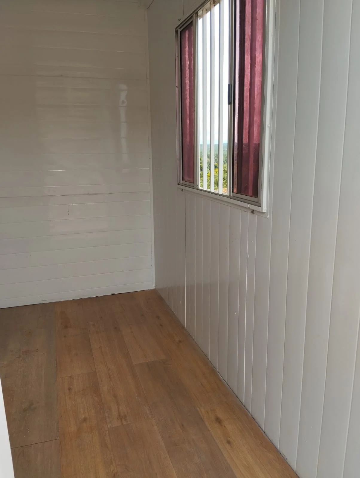 Interior do container de obra com piso vinílico e janela em Minas Gerais